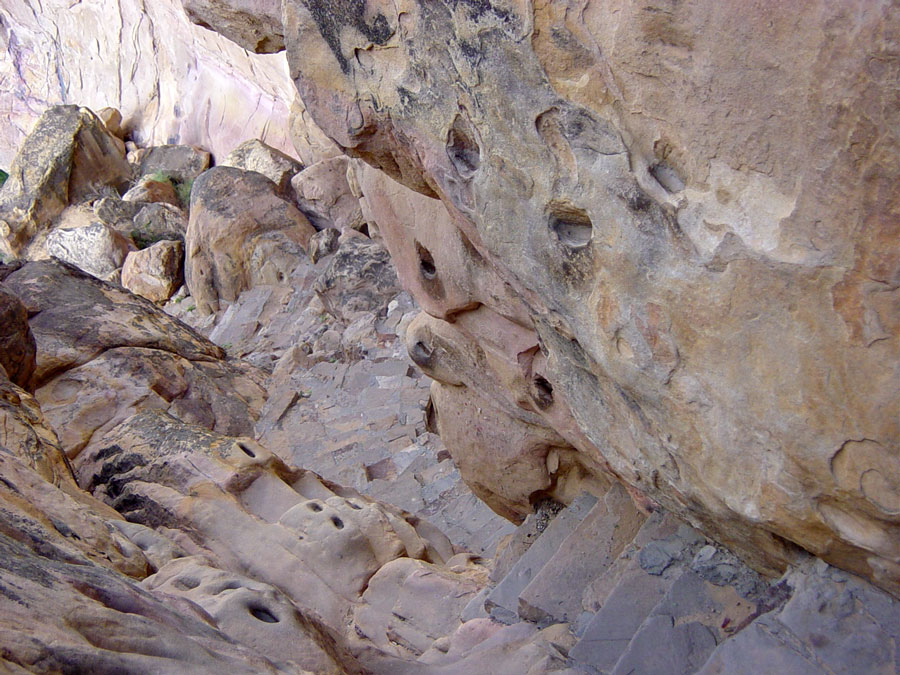 The holes on the side of the path are fingers and toe holds to help people get up and down the mesa.