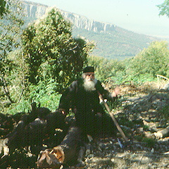 old monk chopping wood Bulgaria