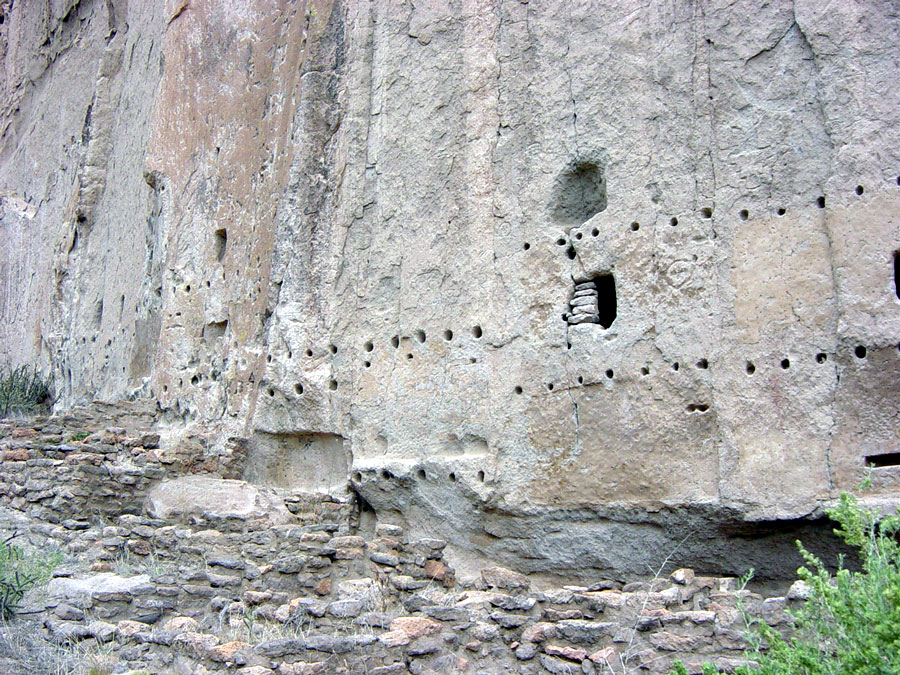 Cliff face dotted with caves and vigas holes