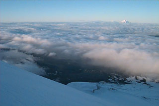 Mountain climbing up Mt. Hood in Oregon. Notice mountain in background peaking above the clouds.