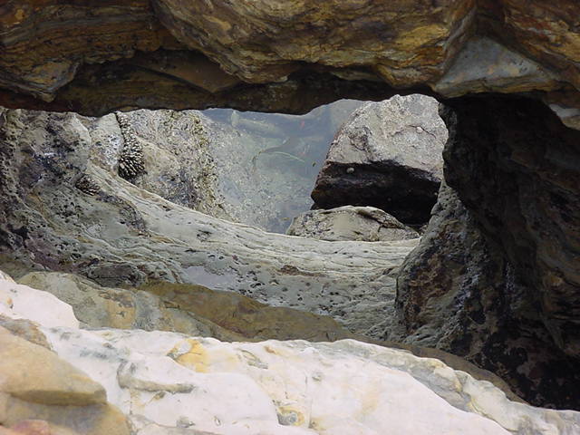 View down a natural chimney into a tide pool