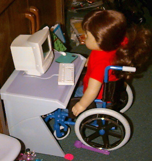 Doll working at her computer desk.
