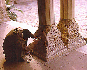 Craftsman at work carving column