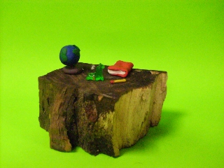 Clay globe, book and pencil on a wooden desk