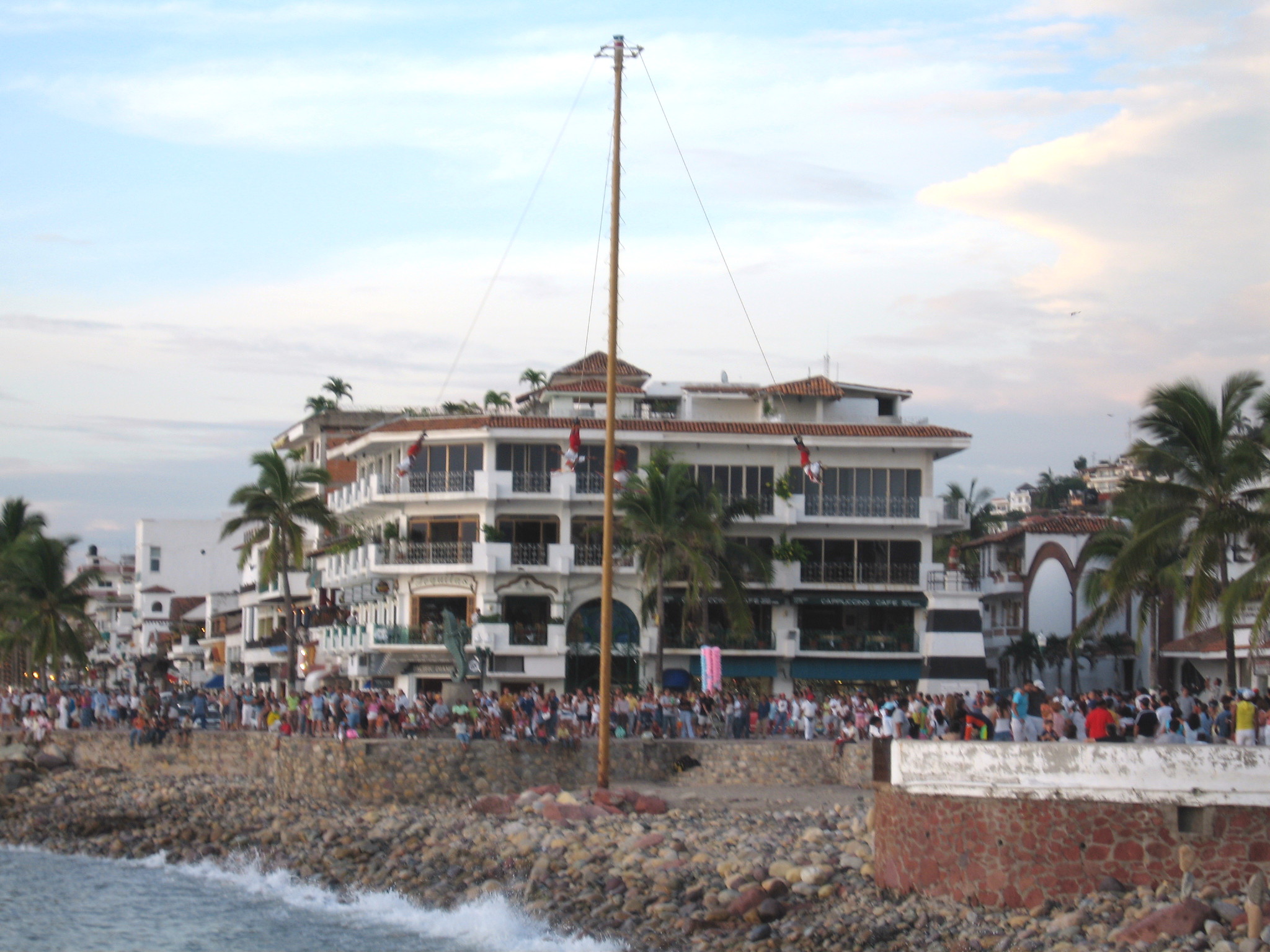 Men swinging down head first from a pole