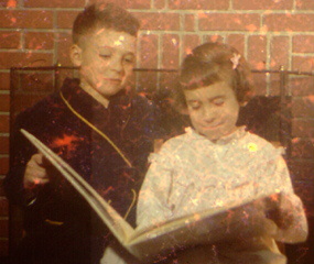 Boy and girl reading by fireplace