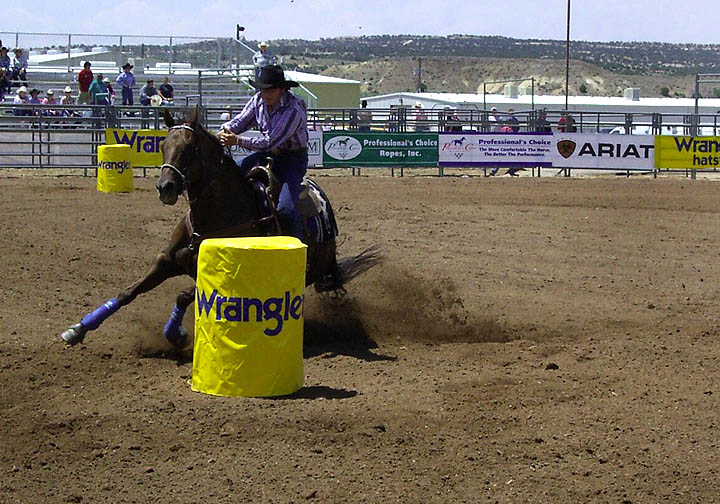 A contestant rides her horse around the course in the barrel racing event.