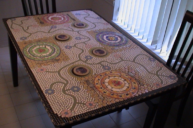 Mosaic topped table created with dishes, tiny tile, round disc tiles, and cove tile.